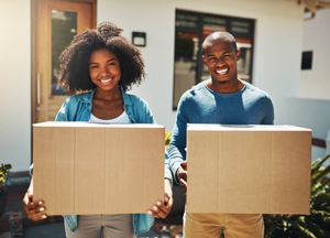 Happy couple moving boxes into new home